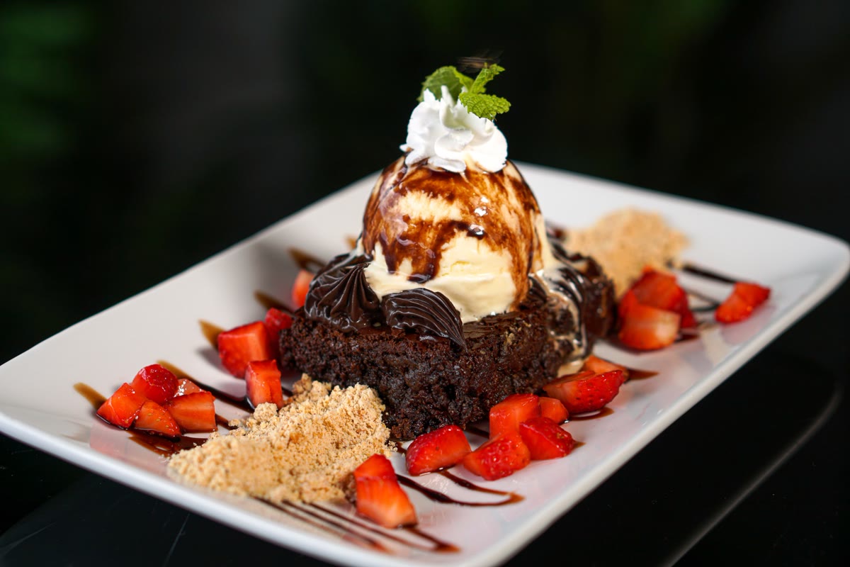Brownie com sorvete, calda de chocolate, chantilly e morangos