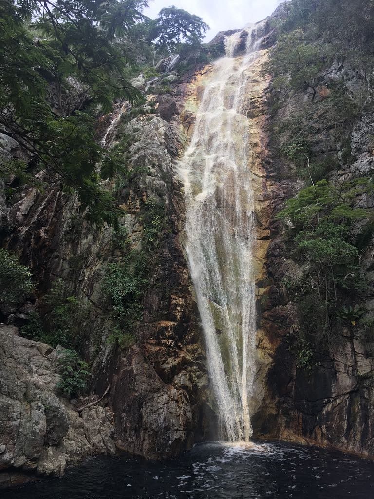 Cachoeira alta caindo entre paredões de pedra em Jacobina