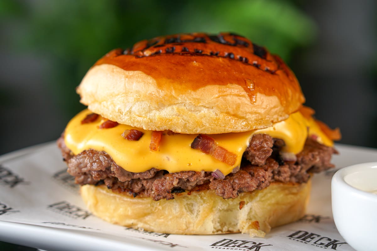 Burger Deluxe com dois smash burgers, nacho cheese e bacon no pão brioche