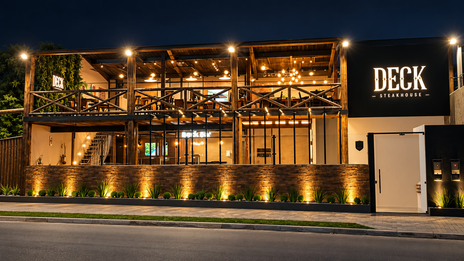 Fachada do Deck Steakhouse à noite, com a varanda de madeira iluminada