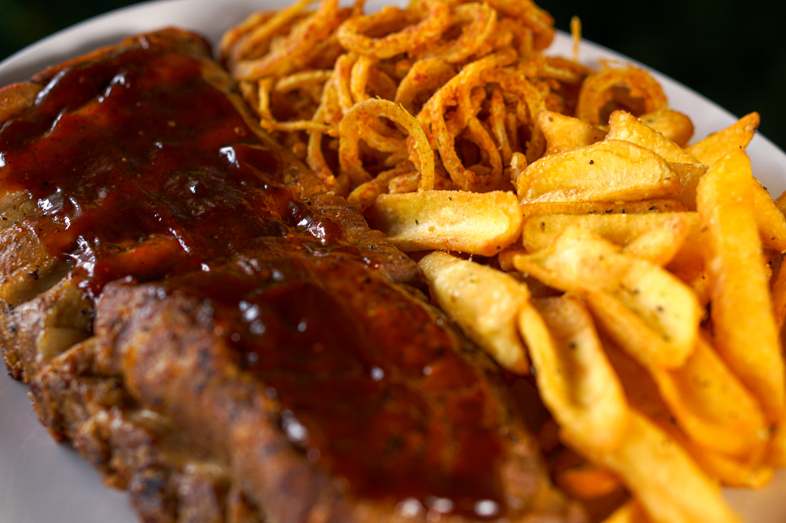Costela coberta de molho barbecue com batata frita e cebola crocante